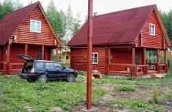 Общий вид дачного участка на продажу - два основных деревянных дома из оцилиндрованного бревна